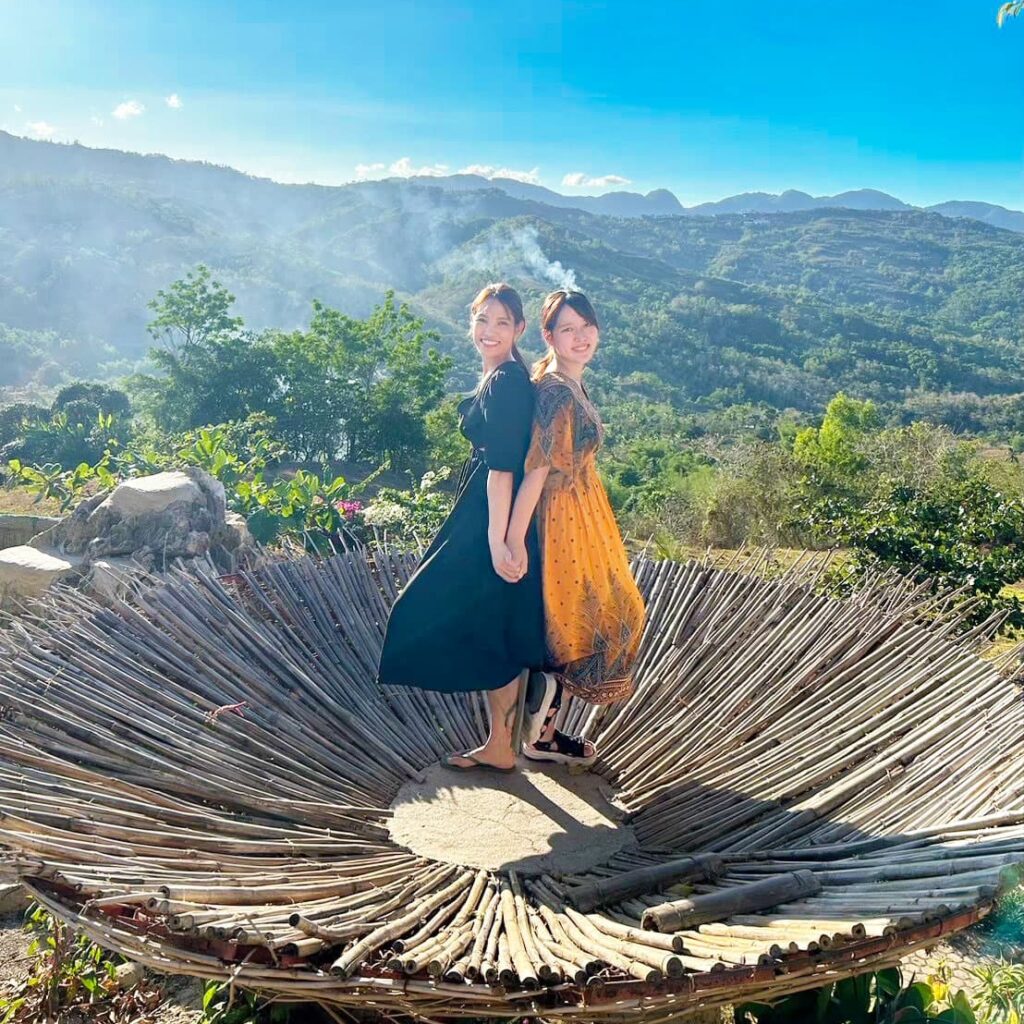 花のようなモニュメント上で写真撮影する女性2人