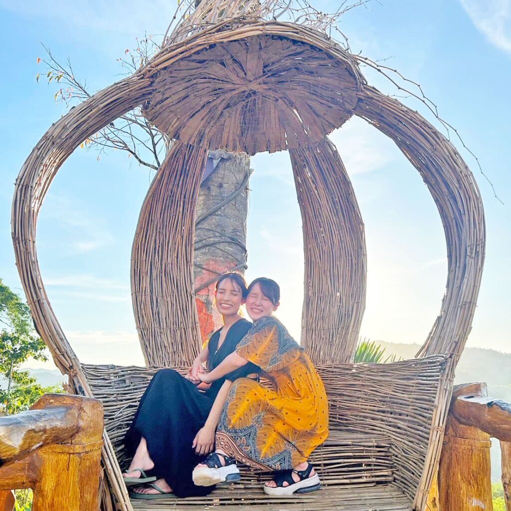 鳥かごのようなモニュメントで写真撮影する女性2人