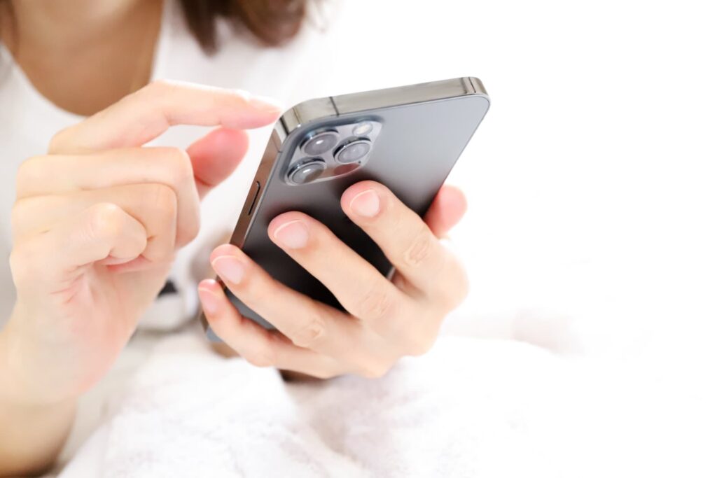 スマホでネット予約をする女性